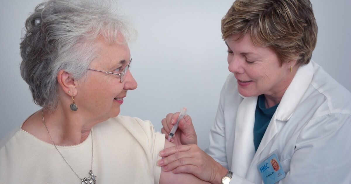 A caregiver organizing medications for an elderly family member at a kitchen table
