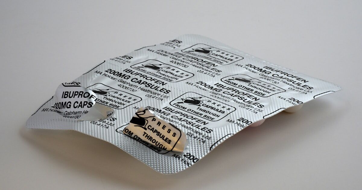 A neatly organized medication station with a pill organizer, glass of water, and smartphone showing reminder notifications